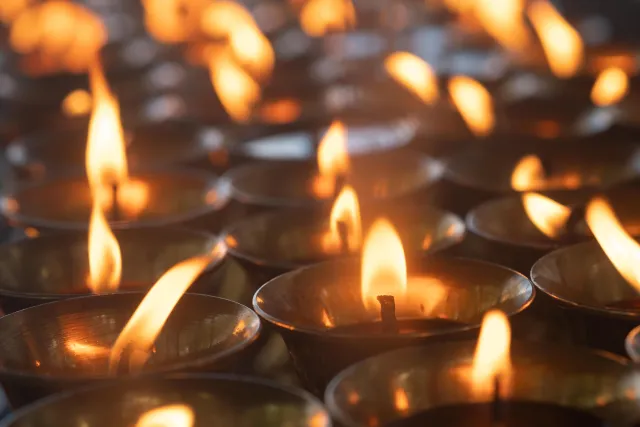 Rows of illuminated golden butter lamps offered in the main prayer hall